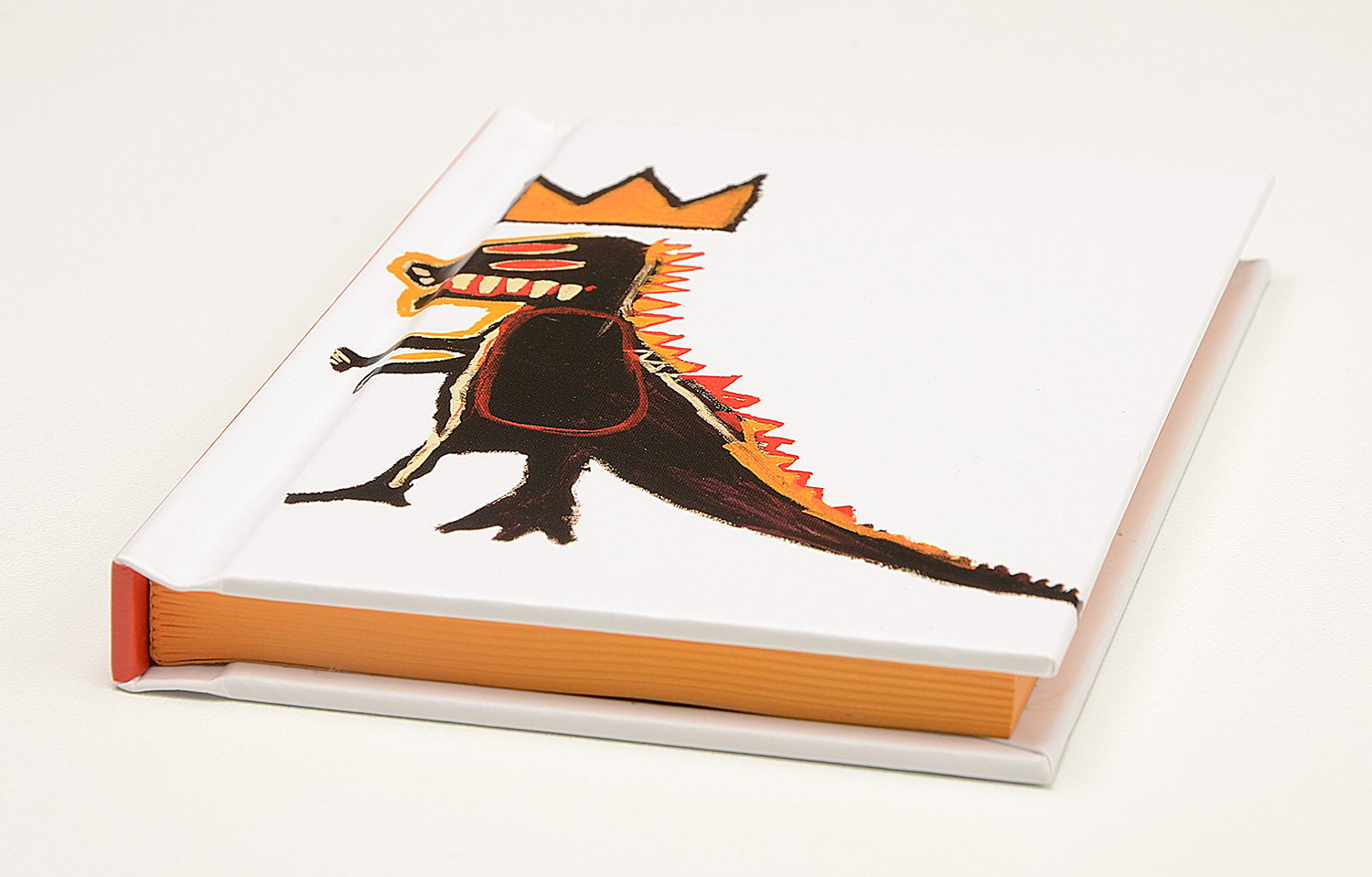 White cover with a quirky bold illustration of a black dinosaur with red eyes with a gold crown above him