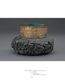 Gold electroplated metal sculpture with enamelled green interior, white cover, JUNE SCHWARCZ Artist in Glass and Metal in grey font above.