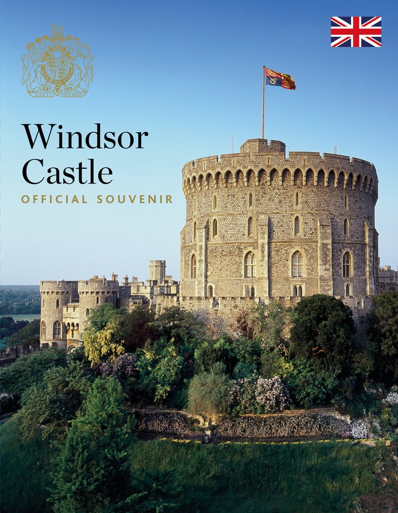 Windsor castle under blue sky, Royal Standard flown above, Windsor Castle OFFICIAL SOUVENIR in navy and gold font to upper left, royal crest above