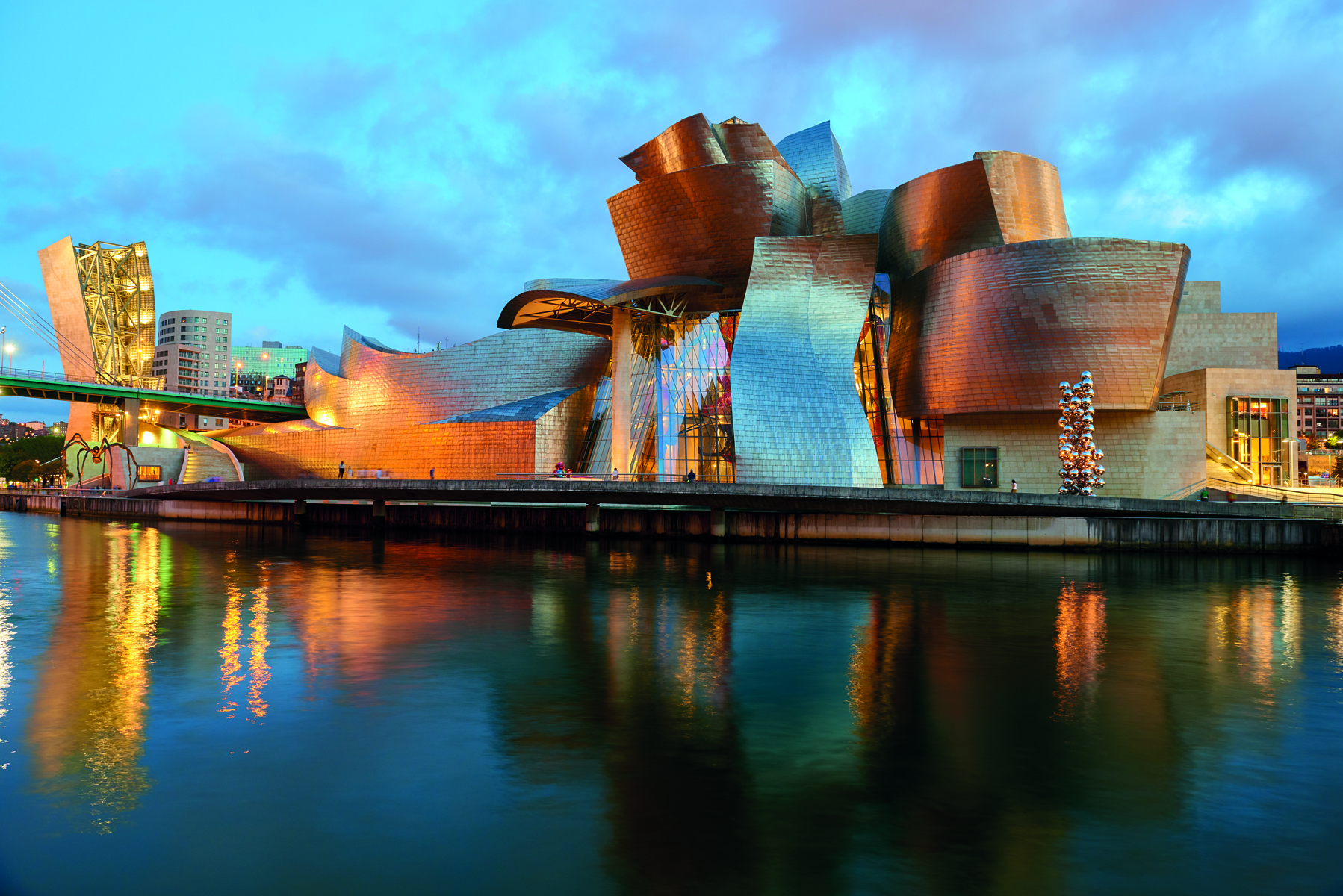 Close up of rusted steel sculpture, The Matter of Time by Richard Serra, GUGGENHEIM MUSEUM BILBAO in white font to centre right.