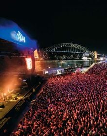 Landscape photo of Sydney Opera House surrounded by blue water, under evening sky, Sydney Opera House OFFICIAL SOUVENIR GUIDE in white font above.