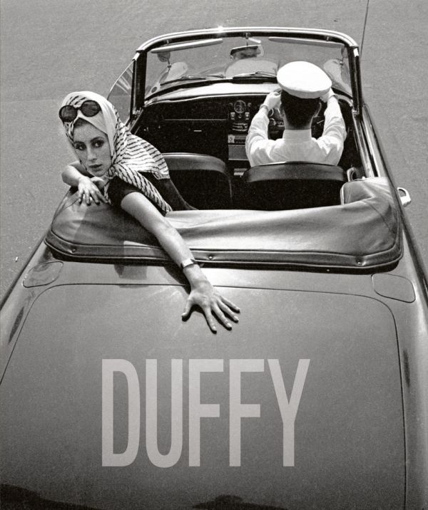 Book cover of Duffy, featuring a fashion model in the back seat of convertible car driven by chauffer. Published by ACC Art Books.
