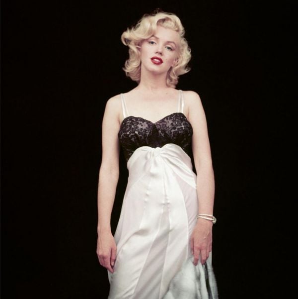 Book cover of The Essential Marilyn Monroe, featuring the actress posing for the negligee Sitting, by Milton H. Greene. Published by ACC Art Books.
