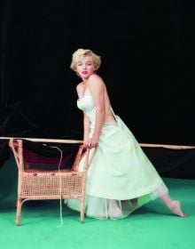 Book cover of The Essential Marilyn Monroe, featuring the actress posing for the negligee Sitting, by Milton H. Greene. Published by ACC Art Books.