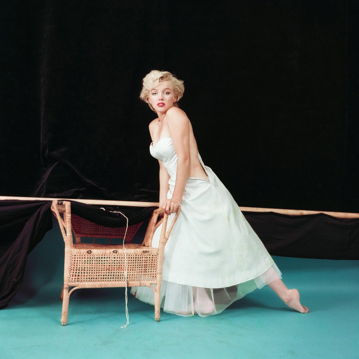 Book cover of The Essential Marilyn Monroe, featuring the actress posing for the negligee Sitting, by Milton H. Greene. Published by ACC Art Books.