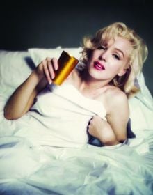 Book cover of The Essential Marilyn Monroe, featuring the actress posing for the negligee Sitting, by Milton H. Greene. Published by ACC Art Books.