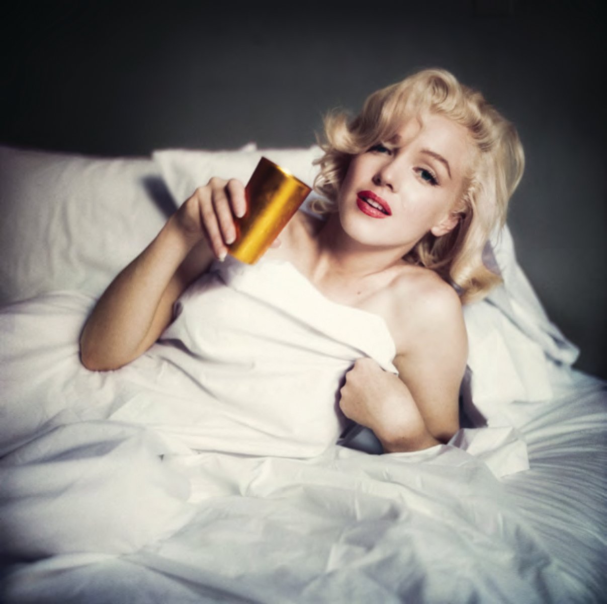 Book cover of The Essential Marilyn Monroe, featuring the actress posing for the negligee Sitting, by Milton H. Greene. Published by ACC Art Books.