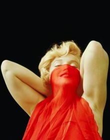 Book cover of The Essential Marilyn Monroe, featuring the actress posing for the negligee Sitting, by Milton H. Greene. Published by ACC Art Books.