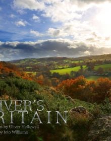 Hilly British landscape with blue cloudy sky above, on cover of 'Oliver's Britain', by ACC Art Books.