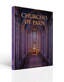 Book cover of Churches of Paris, featuring the atmospheric gothic interior of Sainte-Chapelle in Paris, and stained glass windows with fleurs de lys ceiling decoration. Published by ACC Art Books.