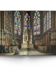 The atmospheric gothic interior of Sainte-Chapelle in Paris, stained glass windows with fleurs de lys ceiling decoration, on cover of 'Churches of Paris', by ACC Art Books.