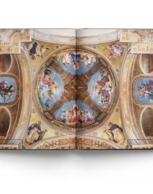 The atmospheric gothic interior of Sainte-Chapelle in Paris, stained glass windows with fleurs de lys ceiling decoration, on cover of 'Churches of Paris', by ACC Art Books.