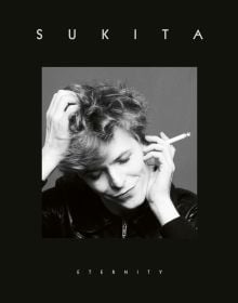 David Bowie with head tilted down, cigarette in hand, on black cover of 'Sukita, Eternity', by ACC Art Books.