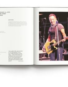 Bruce Springsteen wearing bandana, playing electric guitar on stage, on cover of 'Bruce Springsteen Live in the Heartland Photos by Janet Macoska', by ACC Art Books.