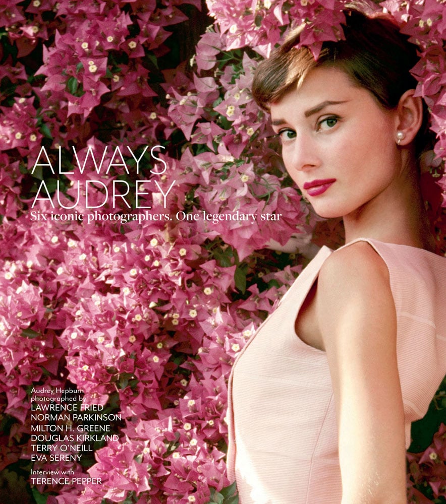 Photograph of Audrey Hepburn in pink dress looking at camera leaning on wall of pink bougainvillea flowers, on front cover of Always Audrey by ACC Art Books