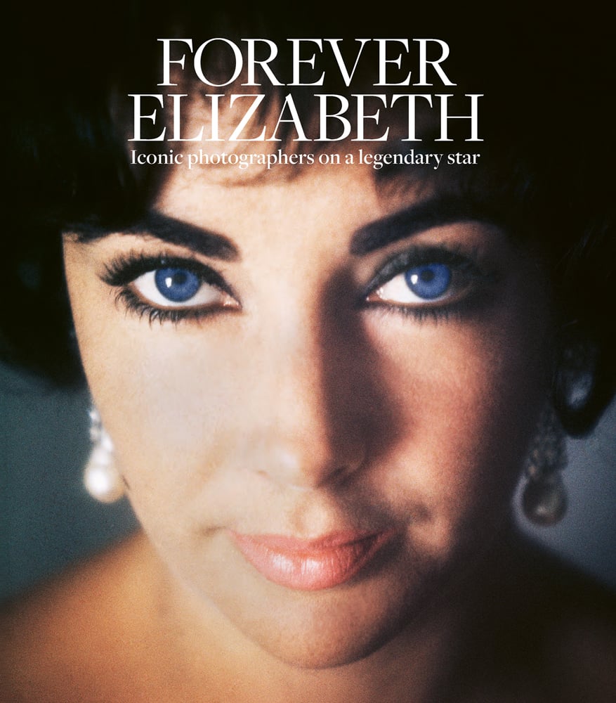 Colour close up photograph of Elizabeth Taylor looking into the camera with blue eyes and Forever Elizabeth Iconic Photographers on a Legendary Star in white