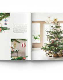 Nordic style white interior with green Christmas tree, on cover of 'THE CHRISTMAS SEASON CREATED BY SCANDINAVIAN ARTISTS', by ACC Art Books.