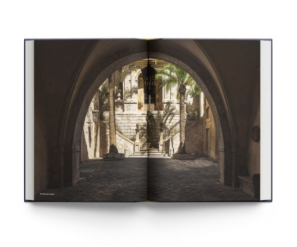 Book cover of A Palace in Sicily, A Masterpiece Restored, featuring an ornate palace chair with gold swan decoration to arm, and gold webbed feet. Published by ACC Art Books.