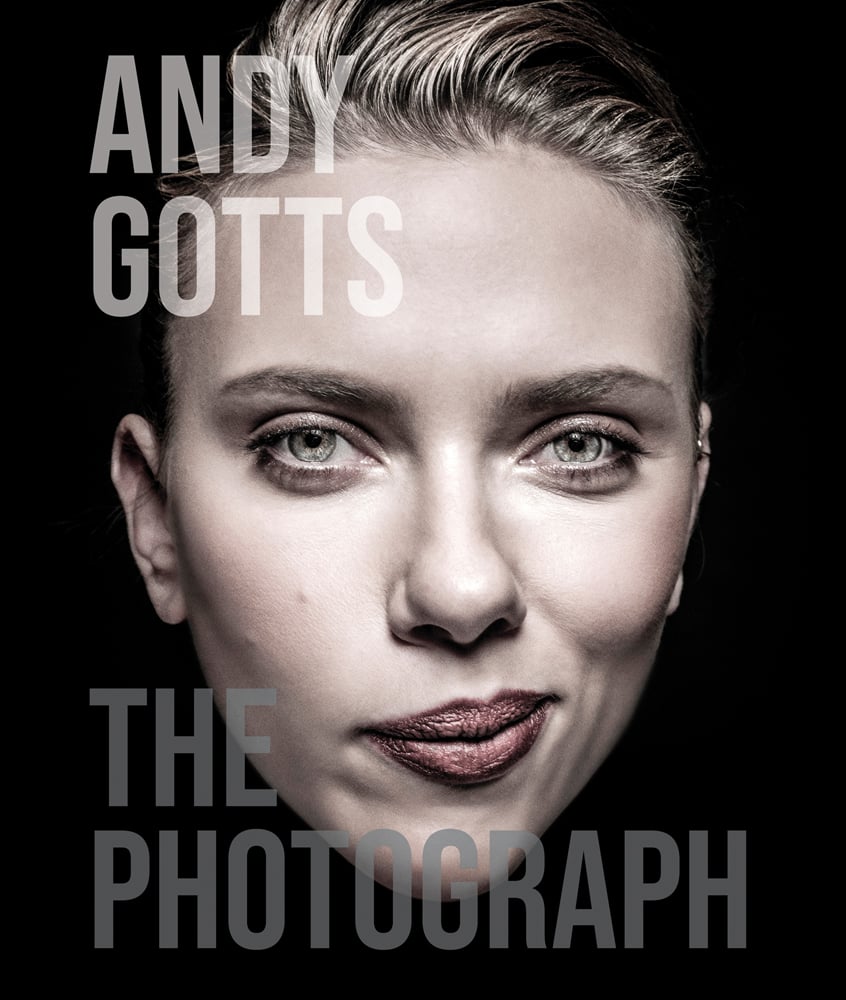 Black cover with a close up full head length colour portrait of Scarlett Johansson with a smirk on her face and Andy Gotts The Photograph in translucent grey by ACC Art Books