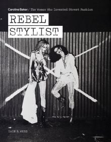 Two fashion models posing in front of corrugated fence with large white X, on cover of 'Rebel Stylist', by ACC Art Books.