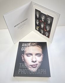 Scarlett Johansson smirking at camera, on black cover of 'Andy Gotts The Photograph; Kylie Minogue Deluxe Edition', by ACC Art Books.