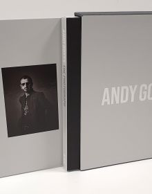 Scarlett Johansson smirking at camera, on black cover of 'Andy Gotts The Photograph; Ringo Starr Deluxe Edition', by ACC Art Books.