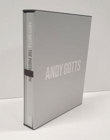 Scarlett Johansson smirking at camera, on black cover of 'Andy Gotts The Photograph; Ringo Starr Deluxe Edition', by ACC Art Books.