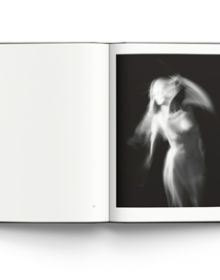 Blurred female nude in movement, on black cover of 'Memory of Light, Steen Evald', by ACC Art Books.