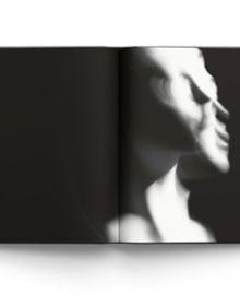 Blurred female nude in movement, on black cover of 'Memory of Light, Steen Evald', by ACC Art Books.