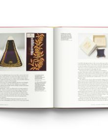 Appliqued English rose emblem in gold, cream and burgundy on beige cover, An Unbroken Thread in gold font to upper left.