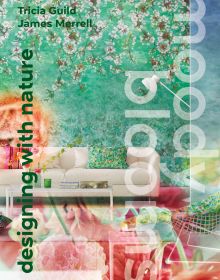 Book cover of Moody Blooms, with an interior space with blossom wallpaper, white sofa and coffee table. Published by ACC Art Books.