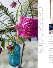 Book cover of Moody Blooms, with an interior space with blossom wallpaper, white sofa and coffee table. Published by ACC Art Books.