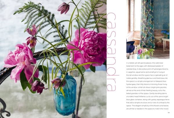 Book cover of Moody Blooms, with an interior space with blossom wallpaper, white sofa and coffee table. Published by ACC Art Books.