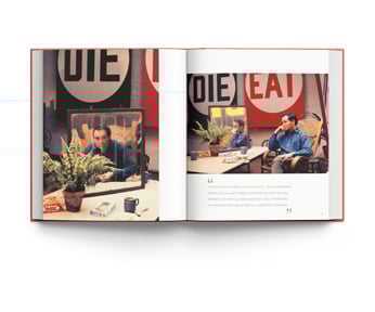 Book cover of William John Kennedy: The Lost Archive: Photographs of Andy Warhol and Robert Indiana, featuring artist Andy Warhol grasping bunch of yellow sunflowers, with bold flower backdrop. Published by ACC Art Books.