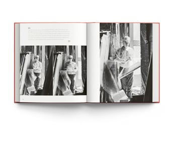 Book cover of William John Kennedy: The Lost Archive: Photographs of Andy Warhol and Robert Indiana, featuring artist Andy Warhol grasping bunch of yellow sunflowers, with bold flower backdrop. Published by ACC Art Books.