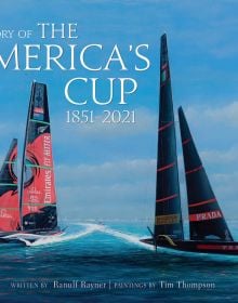 Two large yachts in a race on the ocean, under blue sky, on cover of 'The Story of the America's Cup, 1851-2021', by ACC Art Books.