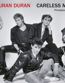 1980s promo studio shot of English new wave Duran Duran, DURAN DURAN CARELESS MEMORIES in red, and black font above.