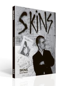 Book cover of Skins, featuring a young white male skinhead in black jacket, with his arms folded, looking to his left, and 'SKINS', in black graffiti on wall behind. Published ACC Art Books.