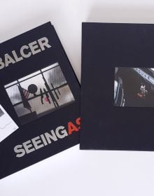Book cover of Seeing As, René Balcer, with a row of knives and a machete, on a magnetic strip, with American flag and globe to left. Published by ACC Art Books.