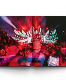 Book cover Liam Bailey's Glastonbury: The Festival and Its People, with festival goers standing at top of hill with tents behind them. Published by ACC Art Books.