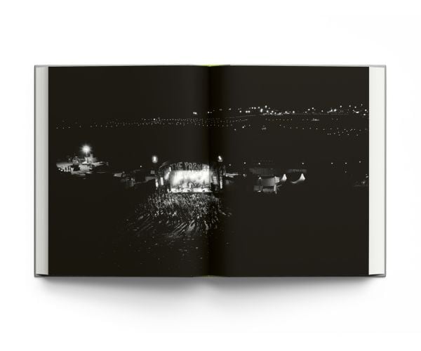 Book cover Liam Bailey's Glastonbury: The Festival and Its People, with festival goers standing at top of hill with tents behind them. Published by ACC Art Books.