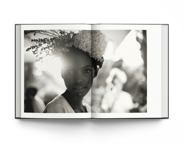 Book cover of La Dolce Vita: Inside the World of Dolce&Gabbana’s Alta Moda Fashion Shows, featuring a model in a large floral dress standing amongst a rocky mountain. Published by ACC Art Books.