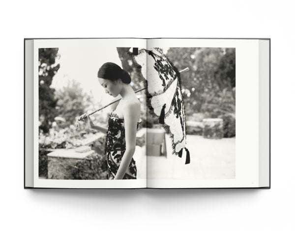 Book cover of La Dolce Vita: Inside the World of Dolce&Gabbana’s Alta Moda Fashion Shows, featuring a model in a large floral dress standing amongst a rocky mountain. Published by ACC Art Books.