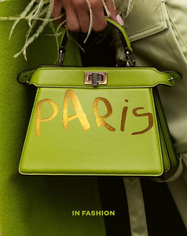 Book cover of Paris. In Fashion; featuring a model holding a green handbag. Published by ACC Art Books.