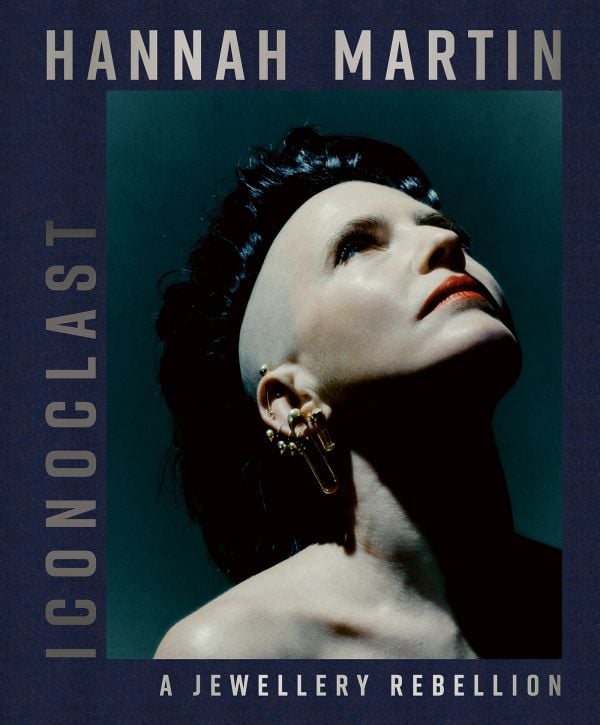 Book cover of Hannah Martin: Iconoclast; featuring the jeweler wearing safety pin earrings. Published by ACC Art Books.
