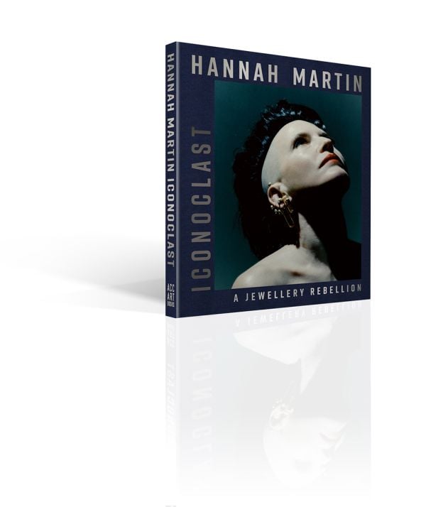 Book cover of Hannah Martin: Iconoclast; featuring the jeweler wearing safety pin earrings. Published by ACC Art Books.