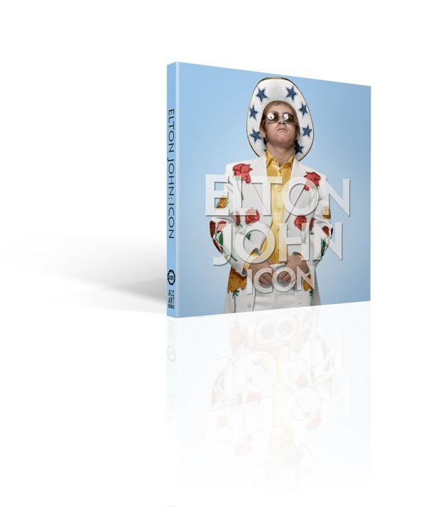 Book cover of Elton John: Icon; featuring the musician wearing a white suit and cowboy hat with blue stars. Published by ACC Art Books.