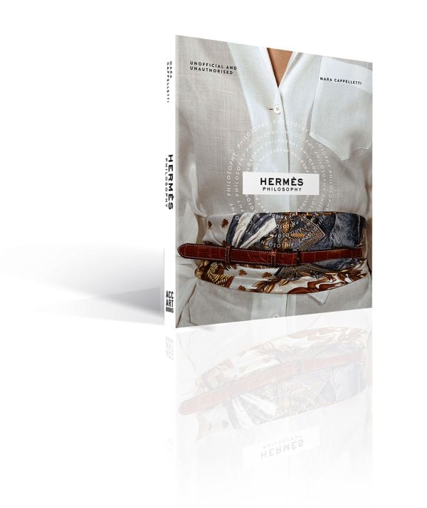 Book cover of Hermés Philosophy; featuring a model wearing a white linen shirt with a fabric and leather belt wrapped around waist. Published by ACC Art Books.