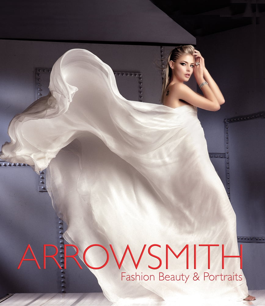 Book cover of Clive Arrowsmith: Fashion, Beauty & Portraits, featuring model Lisa Seffiert in billowing white Gucci dress. Published by ACC Art Books.