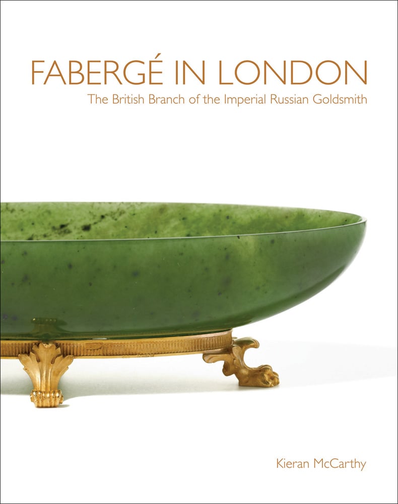 White cover featuring three quarters of a green glass bowl with a gold stand with feet and Fabergé in London The British Branch of the Imperial Russian Goldsmith Kieran McCarthy in gold by ACC Art Books